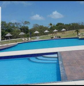 萨利诺波利斯Casa Raizes Salinópolis-PA的一个带椅子和遮阳伞的大型蓝色游泳池