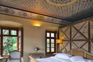 利昂尼迪翁阿尔冲提古奇欧提酒店的一间卧室设有一张带格子天花板的床。