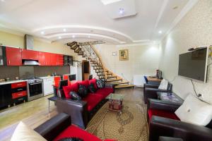 阿哈尔齐赫Guest To Lord Nakashidze的一间带红色沙发的客厅和楼梯