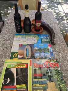 巴统Hotel Liza的一张桌子,上面放有两瓶葡萄酒和一本杂志