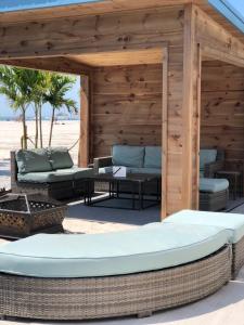 威尔伍德克拉斯特艾克纳钻石海滩酒店 的海滩上带椅子和桌子的木制凉棚