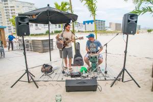 威尔伍德克拉斯特艾克纳钻石海滩酒店 的两个男人在海滩上演奏音乐