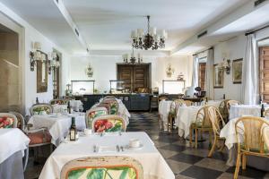 庞特维德拉蓬特韦德拉旅馆的餐厅配有白色的桌椅和吊灯