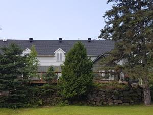 Val-MorinHôtel Far Hills的白色的房子,有栅栏和树木