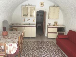 莫托拉Casa Charme的厨房配有桌子和红色沙发