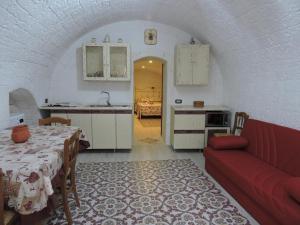 莫托拉Casa Charme的一间厨房,内设桌子和红色沙发