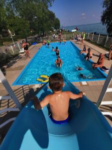 下厄尔什佩尔所营地度假屋的在一个游泳池里乘着蓝色木筏骑着一个男孩子