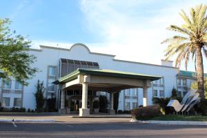 杜兰戈维多利亚快捷酒店的一座白色的大建筑,前面有棕榈树