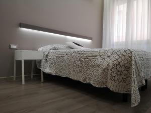 索托马里纳Albergo Felice的一间卧室配有一张带桌子和床罩的床。