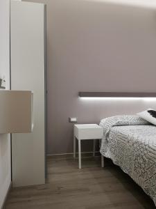 索托马里纳Albergo Felice的白色卧室配有床和桌子