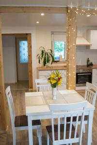 派尔努LiisuPesa Apartment with Sauna and Garden的厨房配有白色餐桌和白色椅子