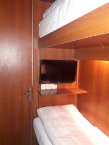 拉巴斯Onkel Inn Airport Sleepbox的一间卧室配有两张双层床和一台平面电视