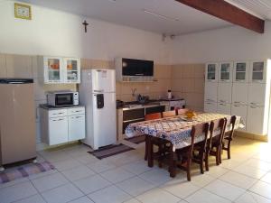 奥林匹亚Casa de Temporada Recanto Fazendinha的厨房配有桌子和白色冰箱。