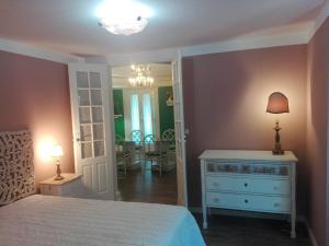 维拉·雷阿尔Casa da Varanda Verde的一间卧室配有一张床、梳妆台和镜子