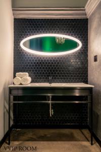 胡志明市HOTEL le JARDIN SECRET saigon的一间带绿色水槽和镜子的浴室