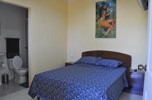 莱昂Cuartos Casa Blanca的一间卧室配有一张带蓝色棉被的床和卫生间。