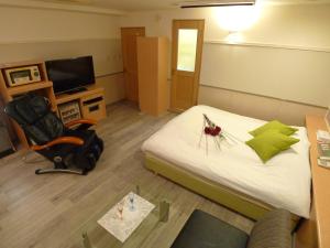横滨Hotel GOLF Hodogaya (Adult Only)的配有床、椅子和电视的房间