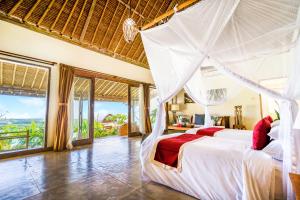 乌鲁瓦图曼陀罗村阳光屋度假村的一间卧室配有一张带蚊帐的床