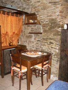Roure TurinMaison Mariot的一张木桌、两把椅子和石墙