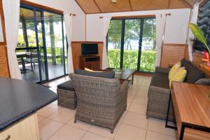 维拉港岛屿魔法公寓度假酒店的客厅配有沙发、椅子和电视