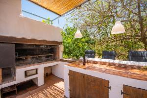 科因Cubo´s Casa Rural La Cañada de Coín的庭院设有带烧烤设施和椅子的酒吧