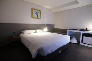 首尔明洞托马斯酒店的卧室配有一张白色大床