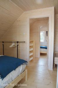 米泽德沃兹Domki Pod Wydmami的木制客房内的一间卧室,配有一张床