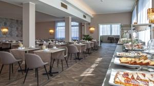 阿巴诺泰尔梅布里斯托尔布加酒店的餐厅设有桌椅,并展示食物