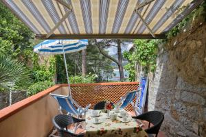 坎波内莱尔巴Residence Vacanza Mare的阳台配有桌椅和遮阳伞