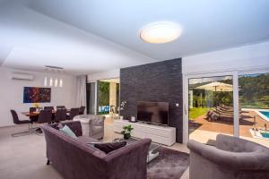 加塔Villa Agava with heated pool, Jacuzzi, sauna, gym, 4 en-suite bedrooms的带沙发、电视和桌子的客厅