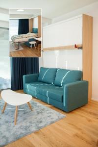 派尔努Riverside Apartment的一间带蓝色沙发的客厅和一间卧室