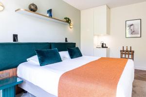 巴黎Hotel Le Friedland的一间卧室配有一张带蓝色枕头的大床