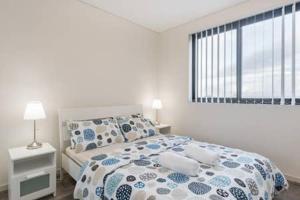 班克斯镇Nice and Clean Apartment with Free Wifi and Netflix的一间卧室配有一张带蓝色和白色床单的床和窗户。