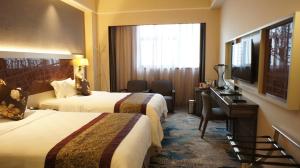 深圳深圳丽都酒店(罗湖)的酒店客房设有两张床、一张桌子和一台电视。