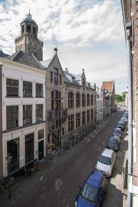迪温特Citystays Deventer的一条有停车车和钟楼城市街道