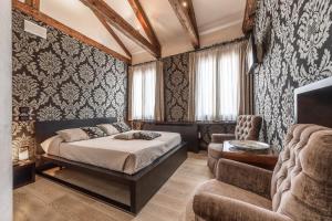 威尼斯阿巴西亚德豪华酒店的一间卧室配有一张床、一张沙发和一把椅子