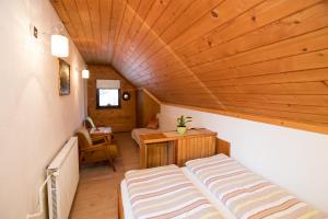 博希尼Sobe Odar Andrej的小房间设有床铺和木制天花板