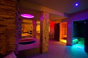 JasenicaZbojnicky penzion的一间设有一张床和紫色照明的房间