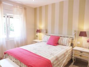Villasuso de CiezaEl Corro, acogedora casa con jardín en el corazón de Cantabria的一间卧室配有粉红色的床和2个床头柜