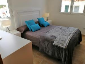 埃斯·梅卡达尔VILLA DIPLOMADO (RELAX EN EL PARAISO)的一间卧室配有一张带蓝色枕头的大床