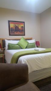 克鲁格斯多普非洲天空旅馆的一间卧室配有两张带绿色枕头的床