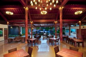 库塔菲布瑞温泉酒店的餐厅设有木桌、椅子和吊灯。
