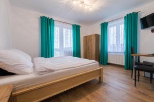 波拉齐克Willa Nova的一间卧室配有一张带绿色窗帘的床和一张书桌
