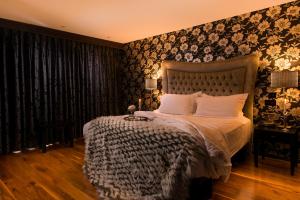 巴纳特尔福酒店的一间卧室配有一张床和一张带花卉壁纸的墙壁