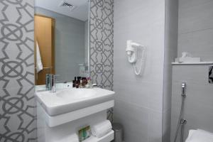 麦纳麦ibis Styles Manama Diplomatic Area的白色的浴室设有水槽和镜子
