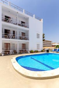 克罗姆港圣弗朗西斯住宅旅馆的一座白色的大建筑,前面设有一个游泳池