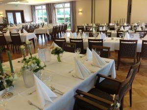 萨尔贝克斯提格曼酒店餐厅的一间设有白色桌椅的用餐室