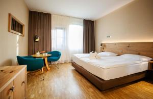 巴特布卢毛布鲁茂百水温泉大饭店的酒店客房带一张床、一张桌子和椅子