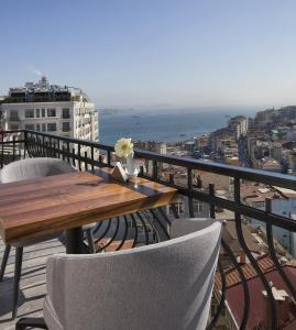 伊斯坦布尔Juno Hotel Taksim的阳台上的木桌和椅子