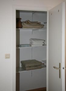 柏林公园绿洲公寓 的配有白色架子和折叠毛巾的衣柜
